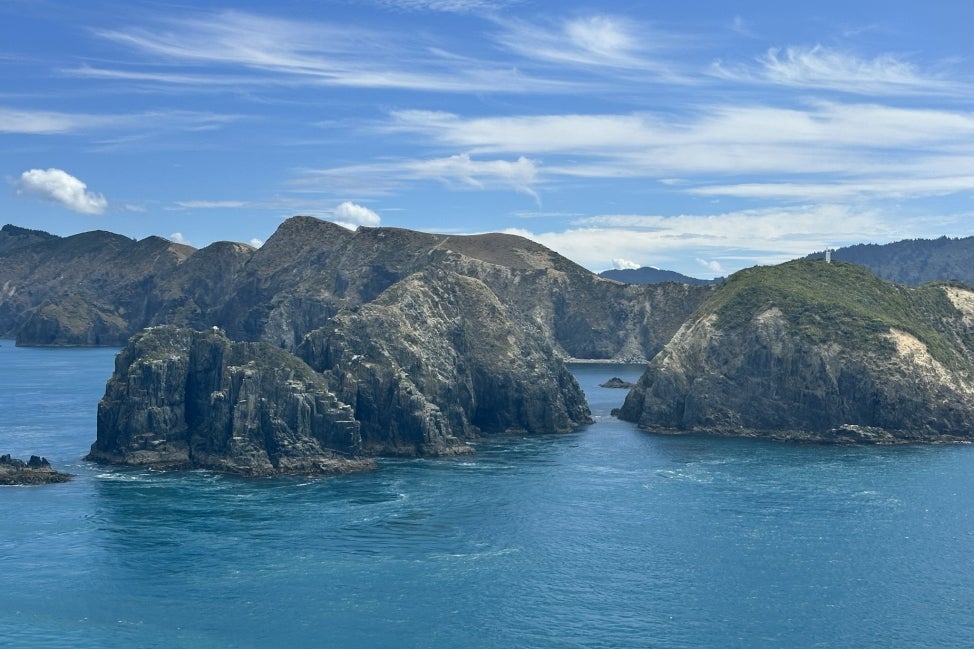 An aerial view of a large body of bright blue water with large protruding masses of land throughout.