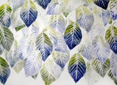 A sheet of white paper covered in prints of a leaf with green and blue ink. 